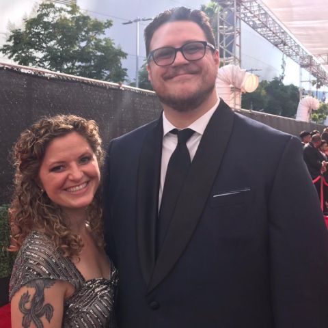 Cameron Britton with his spouse at an event.